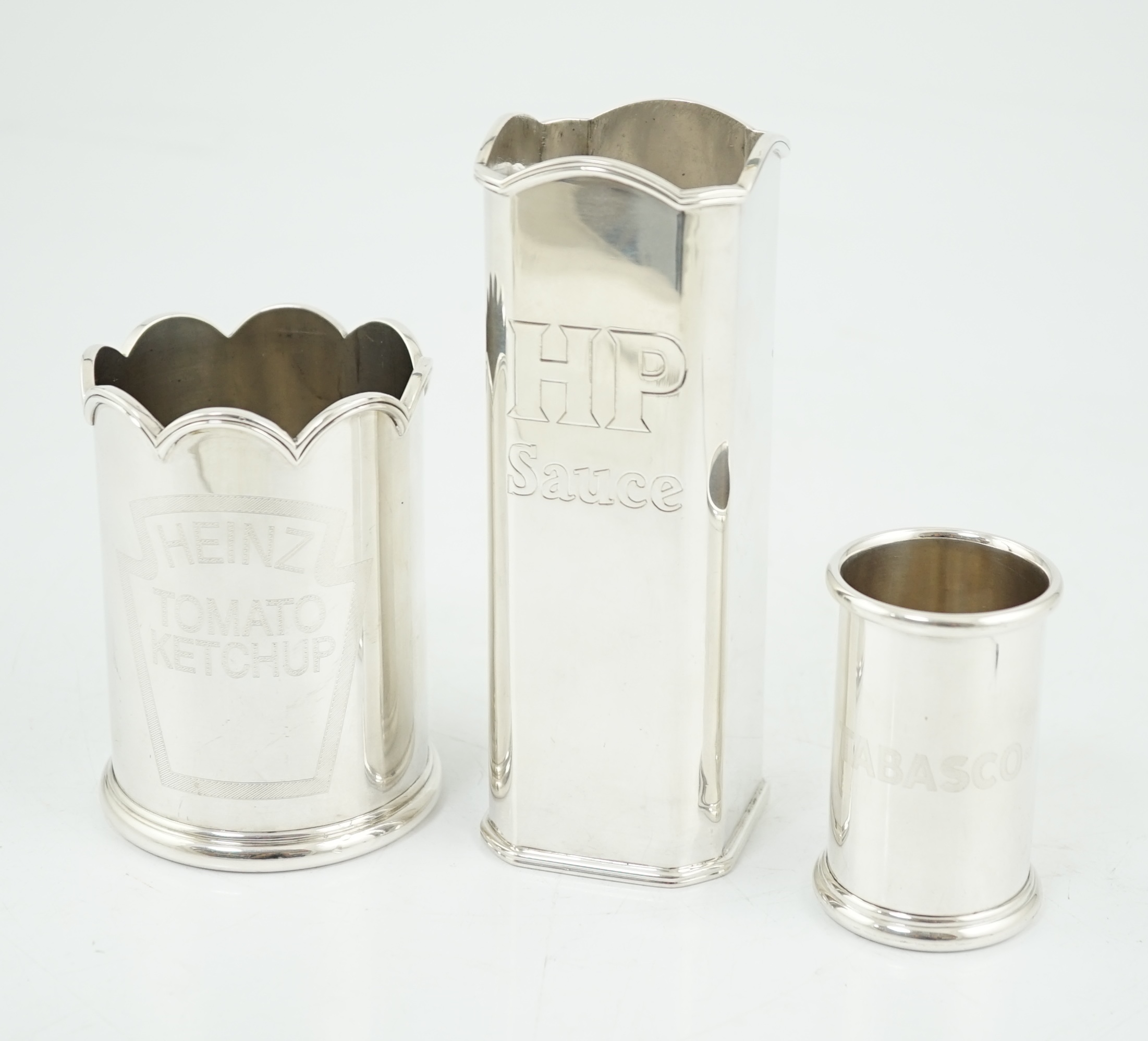 Three assorted Elizabeth II Theo Fennell silver bottle holders